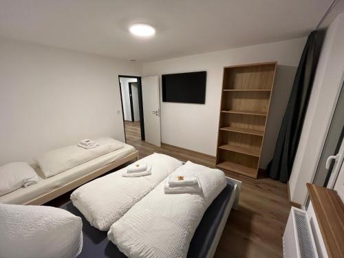 a room with two beds and a flat screen tv at Frisch renovierte Ferienwohnung in Oberstaufen