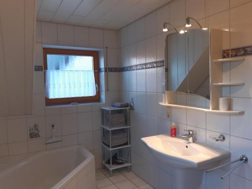 y baño con lavabo, bañera y espejo. en Ferienwohnung Lechleiter, en Kappelrodeck
