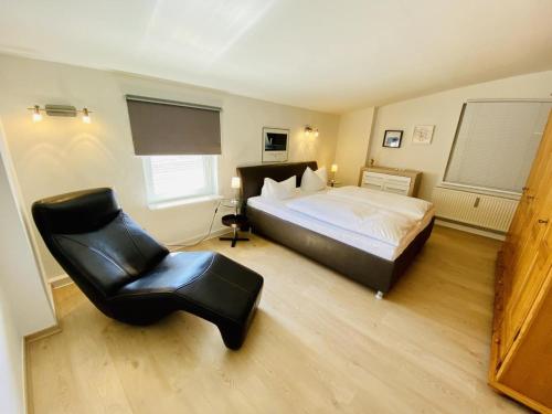 - une chambre avec un lit et une chaise noire dans l'établissement Sterne, à Warnemünde