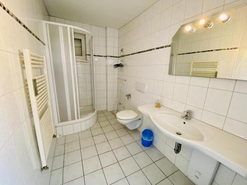 ein weißes Bad mit einem WC und einem Waschbecken in der Unterkunft Sterne in Warnemünde