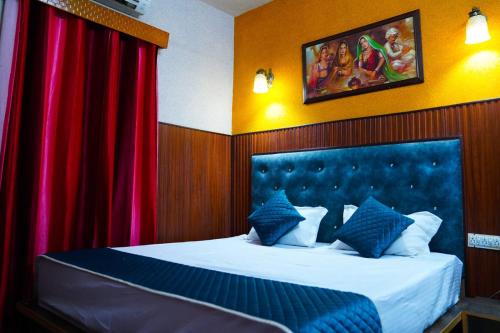 a bedroom with a large bed with red curtains at Hotel Apna Niwas in Una