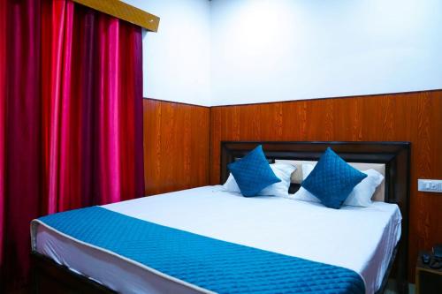 a bedroom with a bed with blue and red curtains at Hotel Apna Niwas in Una