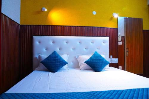 a bedroom with a large bed with blue pillows at Hotel Apna Niwas in Una