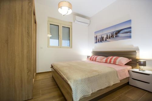 een slaapkamer met een bed en een schilderij aan de muur bij Lux apartment Amarin in Pržno