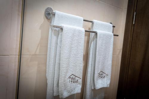 three towels hanging on a towel rack in a bathroom at Family Hotel Pak Tam in Karlovo