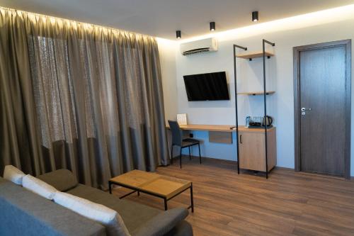 ein Wohnzimmer mit einem Sofa und einem Schreibtisch in der Unterkunft Family Hotel Pak Tam in Karlowo