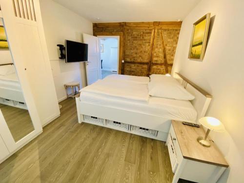 a small bedroom with a bed and a tv at Stromkaje in Warnemünde