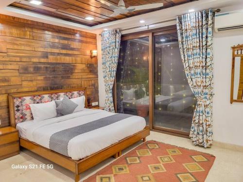 - une chambre avec un lit et une grande fenêtre dans l'établissement Pratishtha 4BHK, DLF Phase 1, Gurgaon, à Gurgaon