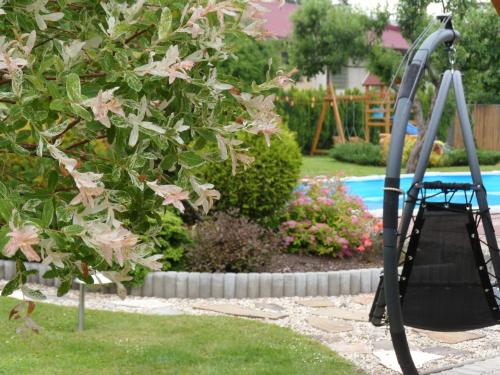 a swing in a yard next to a pool at Apartmány Lea in Liptovský Mikuláš