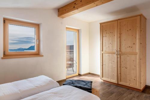 a bedroom with two beds and a window at Reiterhof Apt Gaia in San Genesio Atesino