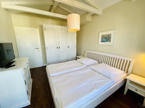 Schlafzimmer mit einem großen weißen Bett und einem Schreibtisch in der Unterkunft Villa Seevogel/Lachmöwe in Warnemünde