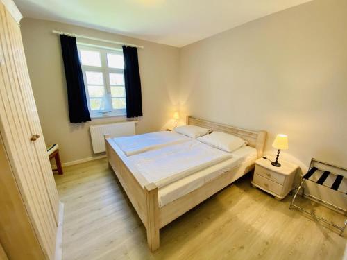 ein Schlafzimmer mit einem großen Bett und einem Fenster in der Unterkunft Wald & Meer/Kapitänsdeck in Warnemünde
