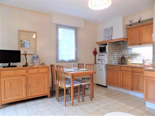 eine Küche mit einem Tisch und Stühlen in der Unterkunft Saint Georges de Didonne - BEL APPARTEMENT résidence boisée PROCHE MER in Saint-Georges-de-Didonne