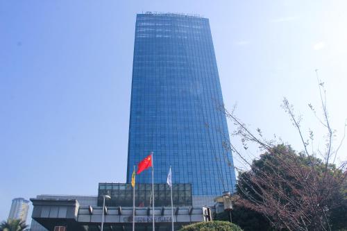 a tall glass building with a red flag in front of it at Expo Center Hotel - Free Shuttle Bus & Late Check-out in Yiwu