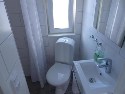 La salle de bains est pourvue de toilettes, d'un lavabo et d'une fenêtre. dans l'établissement Mini-villa 200 m from Kampinge beach, à Höllviken