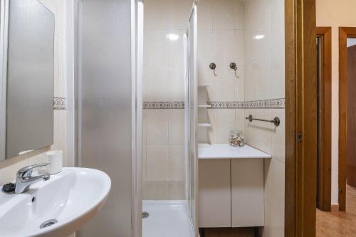 a white bathroom with a sink and a shower at Apartamento Miramar in Cala del Moral