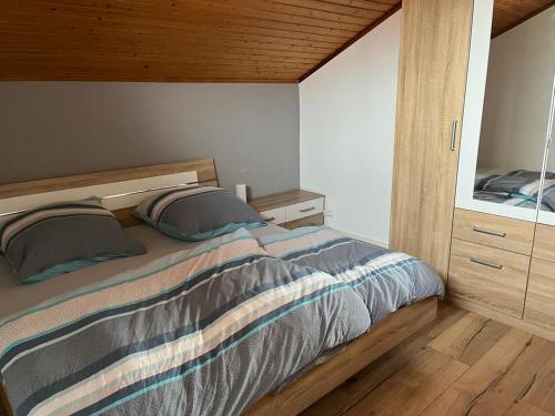 1 dormitorio con 1 cama con 2 almohadas en NEU! FeWo Mansi in Chiemgau en Kienberg