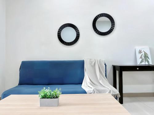 怡保的住宿－The Octagon Ipoh，蓝色的沙发以及带两面镜子的桌子