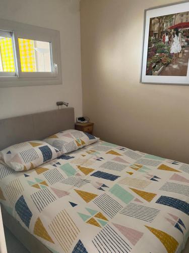 un lit avec une couette dessus dans une chambre dans l'établissement Studio 127, vue mer et piscine, port Santa Lucia, à Saint-Raphaël