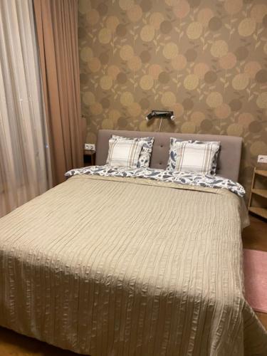 ein Schlafzimmer mit einem Bett mit einer weißen Bettdecke in der Unterkunft Chocolate Apart in Druskininkai