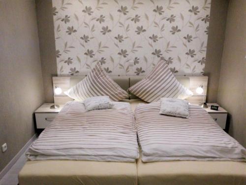 een bed met twee kussens in een slaapkamer bij Ferienpark - Haus K, App 0K0405 in Heiligenhafen