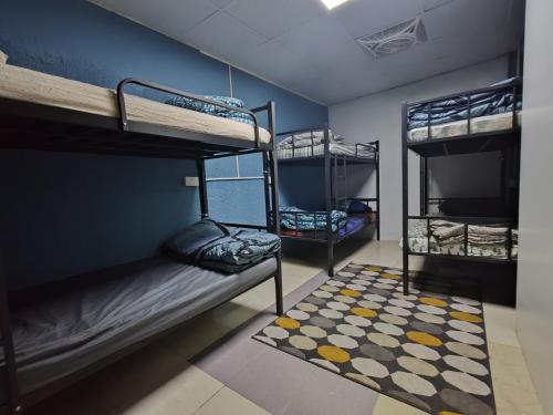 Qamar home rental Deira في دبي: سريرين بطابقين في غرفة مع سجادة