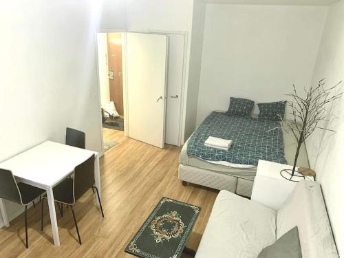 a living room with a bed and a table and a room with a dining room at Compact studio in Ullanlinna in Helsinki