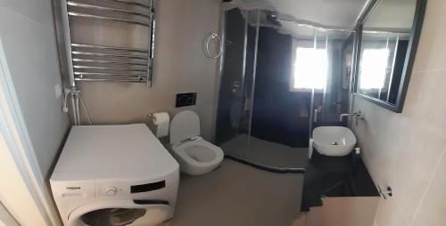 La petite salle de bains est pourvue de toilettes et d'un lavabo. dans l'établissement Glyfada Seabreeze Apartment, à Athènes