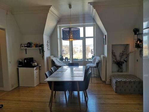 uma sala de estar com uma mesa e cadeiras num quarto em Stor lägenhet för familj eller företag em Norrköping