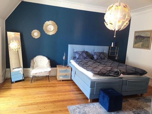 - une chambre avec un lit et un mur bleu dans l'établissement Stor lägenhet för familj eller företag, à Norrköping