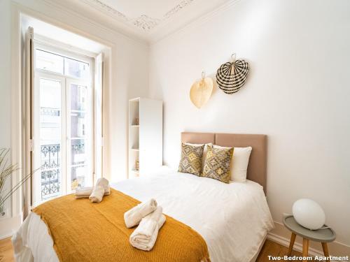 um quarto com uma cama com toalhas em Akicity Ourique Selected em Lisboa