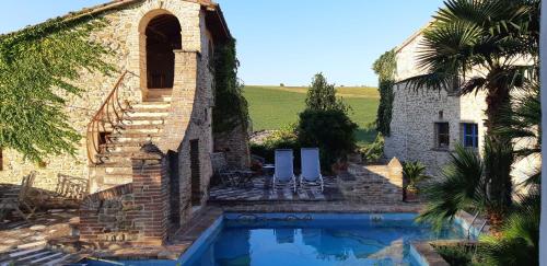 a house with a swimming pool next to a building at Antico-Borgo-Le-Torricelle-Alle-3 in Piandimeleto