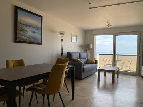 un salon avec une table et un canapé dans l'établissement 1000 - Studio sur la digue du Val André avec magnifique vue mer, à Pléneuf-Val-André