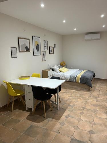 Schlafzimmer mit einem Bett, einem Tisch und Stühlen in der Unterkunft Cabanon provençal in Rochefort-du-Gard