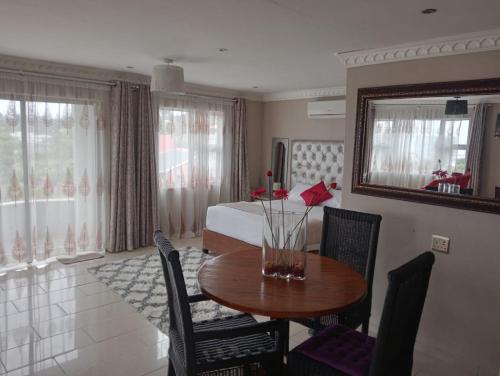 a room with a table and a bedroom with a bed at La Saville BnB in Scottburgh