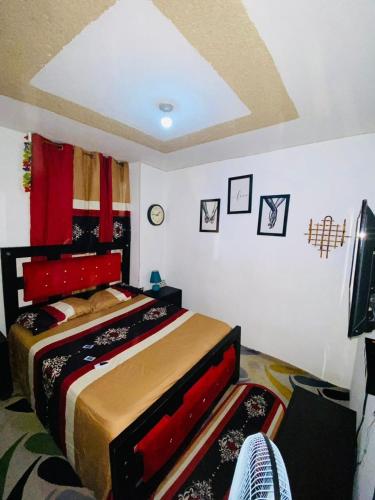 una camera con letto con testiera rossa di Juju Boutique & House a Cap-Haïtien