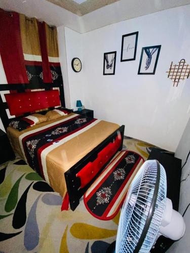 ein Schlafzimmer mit einem Bett und einem Ventilator daneben in der Unterkunft Juju Boutique & House in Cap-Haïtien