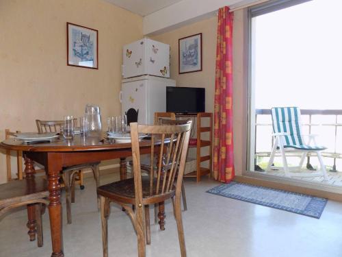 d'une salle à manger avec une table, des chaises et un réfrigérateur. dans l'établissement Saint Georges de Didonne - APPARTEMENT - résidence PROCHE PLAGE avec ascenseur, à Saint-Georges-de-Didonne