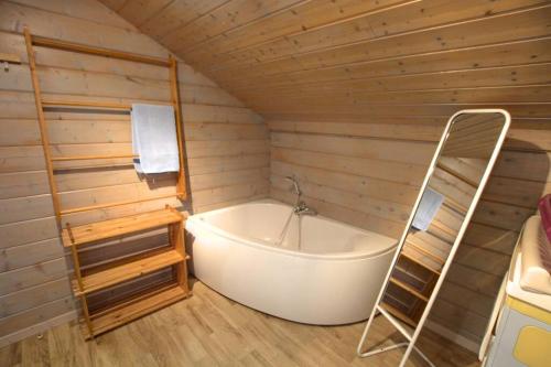 y baño con bañera y escalera. en chalet 3 étoile La bresse avec sauna, en La Bresse