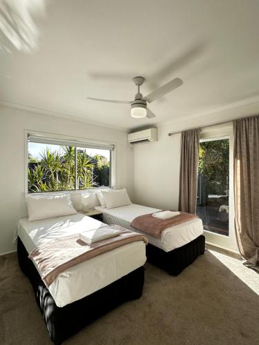 a bedroom with two beds and a window at Tranquil Scape-Villa with Pool by Gold Coast Premium in Gold Coast