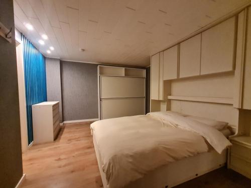 een kleine slaapkamer met een bed en een koelkast bij Gasthuis In't Stad in Nieuwpoort