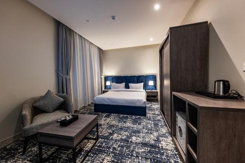 Habitación de hotel con cama y sofá en Towlan Qurtuba 2 en Riad