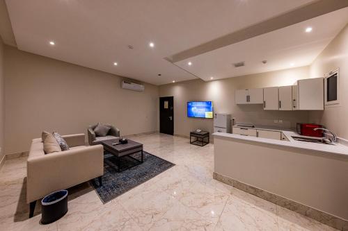 a living room with a couch and a kitchen at Towlan Qurtuba 2 in Riyadh