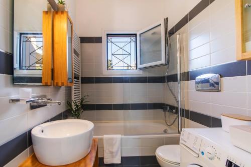 uma casa de banho com uma banheira, um lavatório e um WC. em Lallo Living em Virós