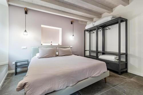 um quarto com uma grande cama branca e uma prateleira em La Casa Incartata - Carta Velina em Toscolano Maderno