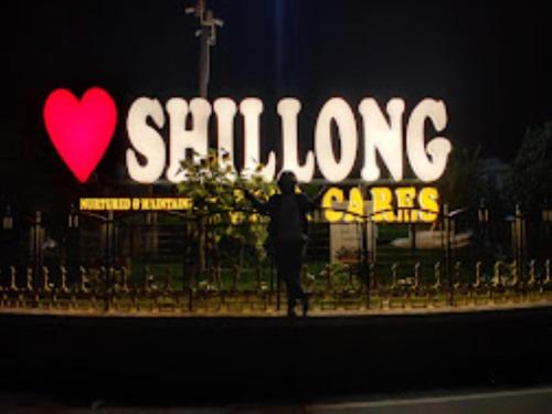 a person standing in front of a sign with a heart at Hotel Monsoon , Shillong in Shillong