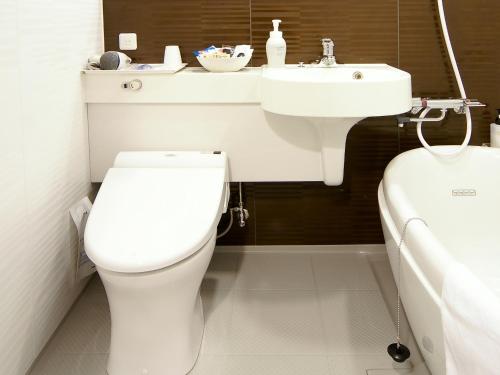 uma casa de banho com um WC branco e um lavatório. em Daiwa Roynet Hotel Osaka Yotsubashi em Osaka