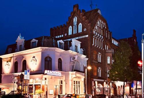 a large brick building in front of a building at Hotel Excellent in Lübeck