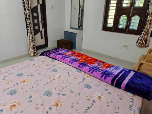 a bed with a purple comforter in a room at Light House Homestay in Mount Ābu