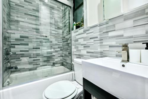 y baño con aseo, ducha y lavamanos. en Central & Cozy 2 BD APT In Manhattan, en Nueva York